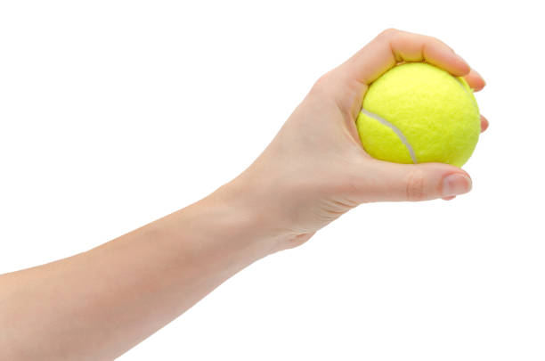 hand of young girl holding tennis ball. hand of young girl holding tennis ball. Isolated on white background tennis ball container stock pictures, royalty-free photos & images