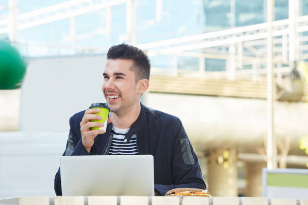 istock handsome man working on laptop at outdoor cafe with coffee 657110370