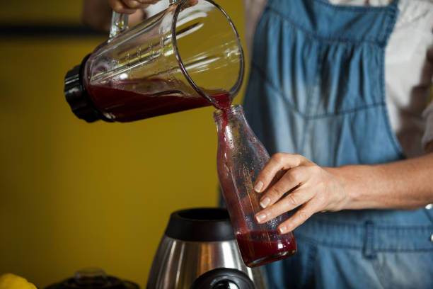 istock Mid-section of female staff preparing a juice 657110506