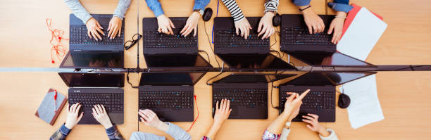 Girls in computer lab coding on laptops Top view of female students learning computer programming. Girls in computer lab coding on laptops. computer-training-concept stock pictures, royalty-free photos & images