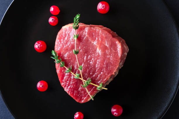 istock Raw meat on black plate and dark background 657123030