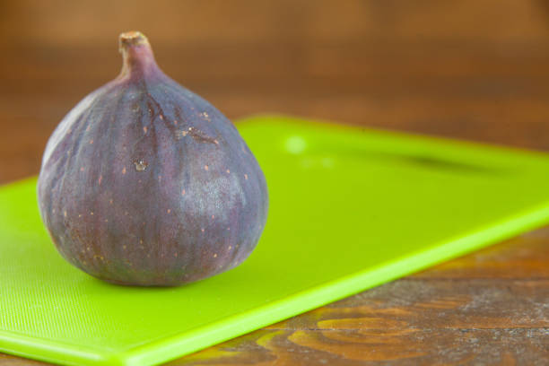 Ripe juicy figs on a green cutting board