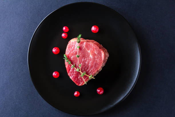 istock Raw meat on black plate and dark background 657126672