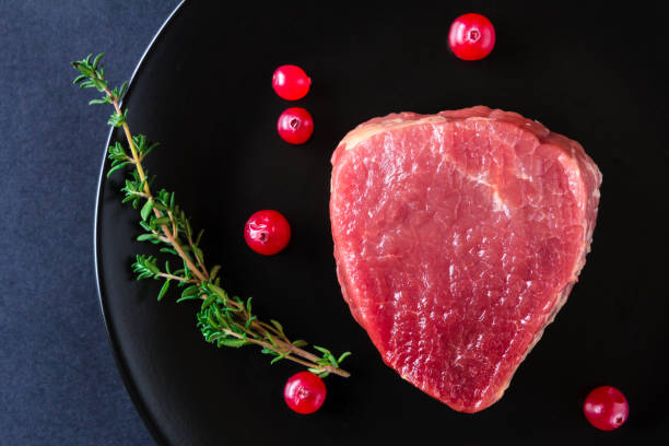 istock Raw meat on black plate and dark background 657129438