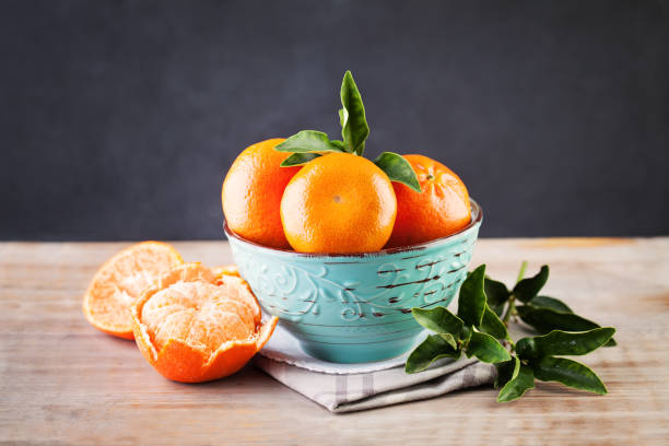 istock Organic Mandarin Fruit in Blue Bowl on Rustic Wooden Background 657130820