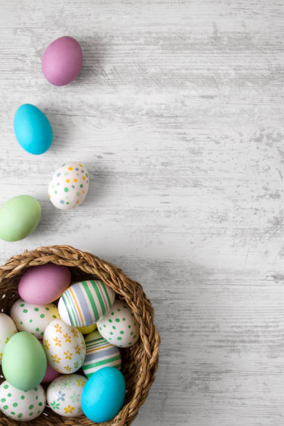 Colorful Easter Eggs Decorated on Wooden Background colorful easter eggs in wicker moses basket stock pictures, royalty-free photos & images