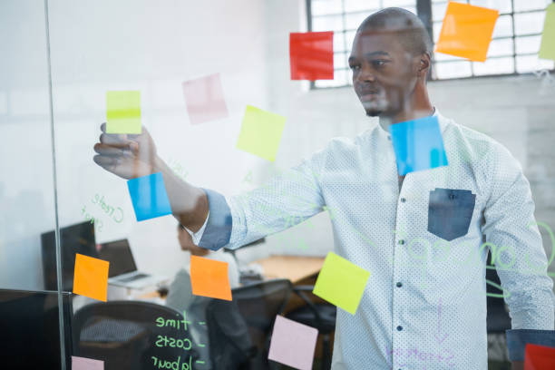 istock Businessman reading sticky notes on glass 657150112