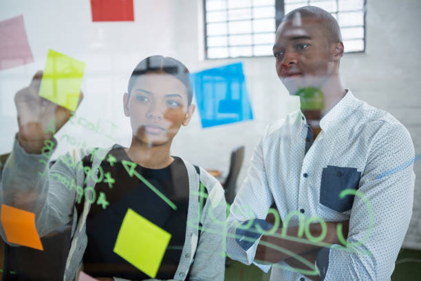 istock Business colleagues reading sticky notes on glass 657152554