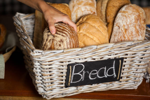 istock Female staff holding breads at counter in bakery shop 657153408