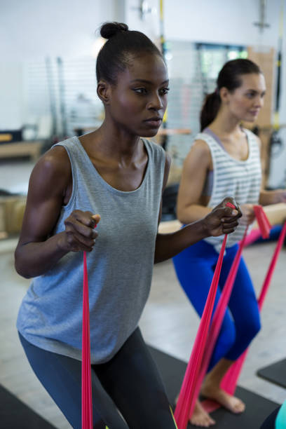 istock Fit women performing stretching exercise with resistance band 657153594