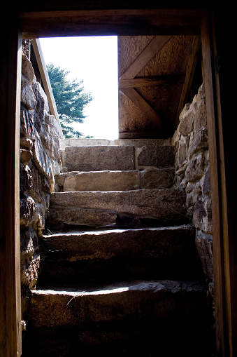 View of the door and stairs from inside a root cellar on a traditional American homestead in Maine.