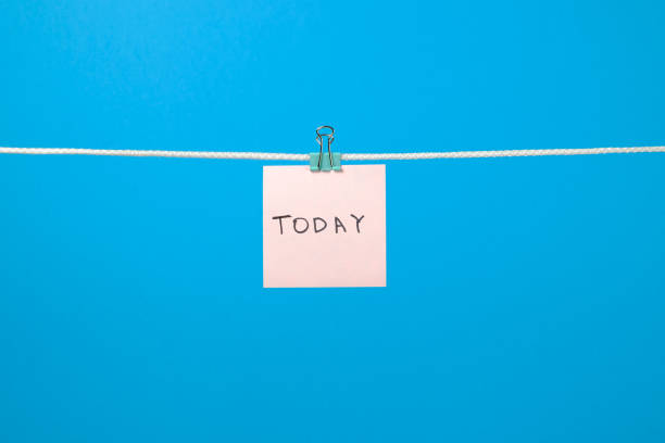 istock Pink paper note hanging on the string with text Today over colorful background 657163726
