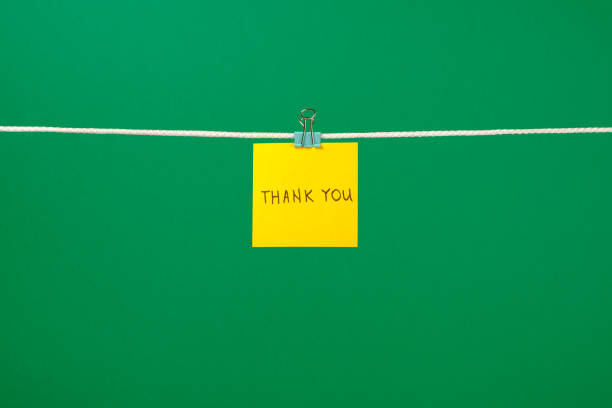istock Yellow paper note on clothesline with text Thank You over colorful background 657163752