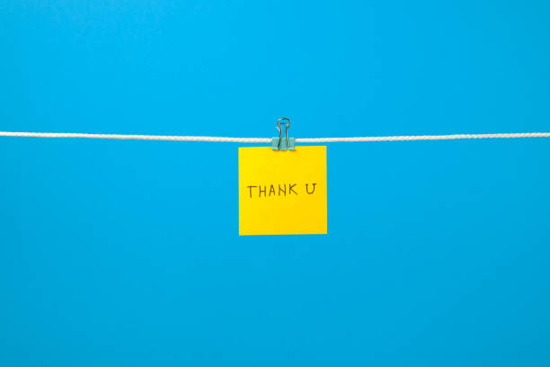istock Yellow paper note on clothesline with text Thank U over colorful background 657163790