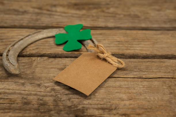 istock St Patricks Day horseshoe with empty tag and shamrock on wooden table 657164328