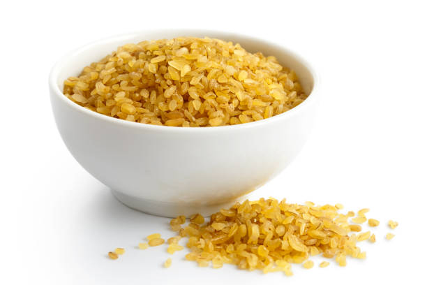 istock Dry bulgur wheat in white ceramic bowl isolated on white. Spilled bulgur. 657171718