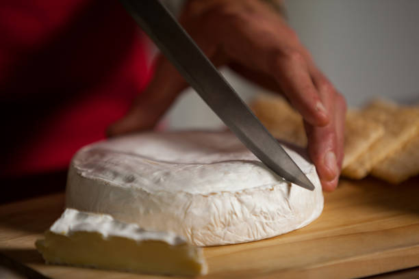 istock Staff cutting cheese at counter in market 657174268