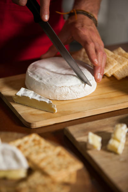 istock Staff cutting cheese at counter in market 657174312