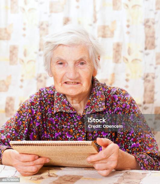 Elderly Happy Woman Read Something From The Book Stock Photo - Download Image Now - Adult, Adults Only, Aging Process