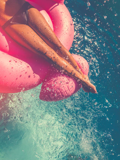 istock Woman floating on a pink inflatable in swimming pool. 657181210