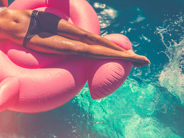 istock Woman floating on a pink inflatable in swimming pool. 657181222