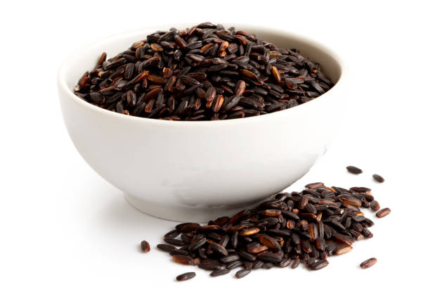 istock Bowl of Nerone black long grain rice isolated on white. Spilled rice. 657184978