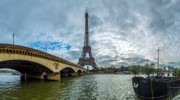 istock Panoramic view of the Eiffel Tower and Jena bridge from the river Seine embankment. Dramatic cloudscape. Paris, France. 657187656