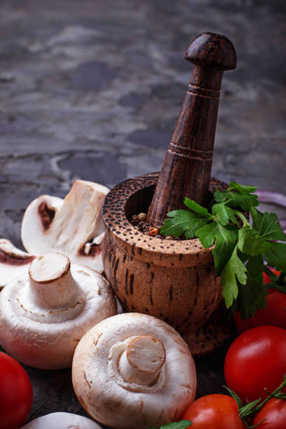 Champignon mushrooms, cherry tomatoes and mortar for spices Champignon mushrooms, cherry tomatoes and mortar for spices. Selective focus dissected flower stock pictures, royalty-free photos & images