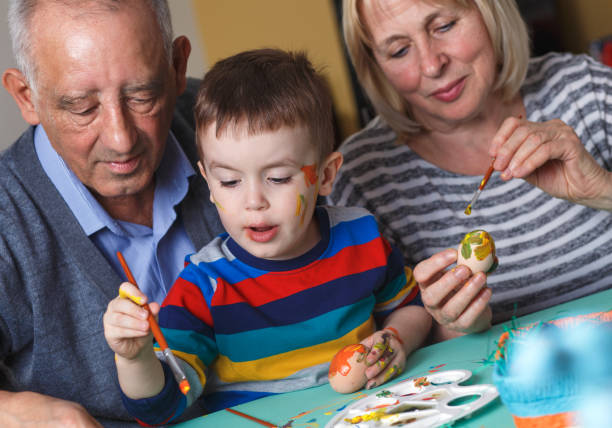 istock Grandmother and grandfather with grandson preparing eggs for Easter. 657206796
