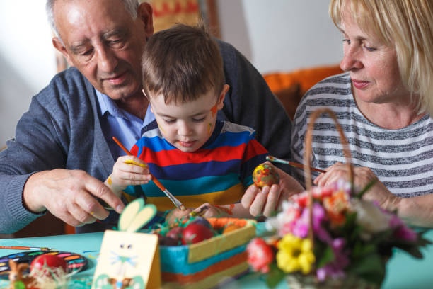 istock Grandmother and grandfather with grandson preparing eggs for Easter. 657207564