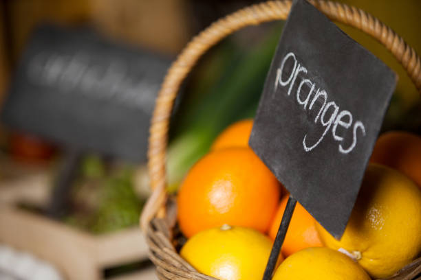 Close-up of fresh oranges in wicker basket with placard in organic section