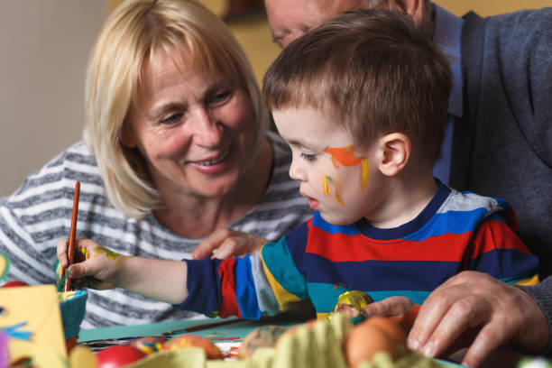 istock Grandmother and grandfather with grandson preparing eggs for Easter. 657214884