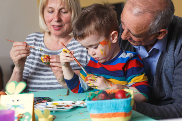 istock Grandmother and grandfather with grandson preparing eggs for Easter. 657215372