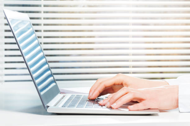 istock Hands typing on laptop keyboard next to the window 657219772