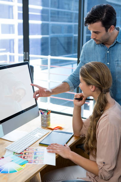 istock Graphic designer working at desk with colleague 657226918