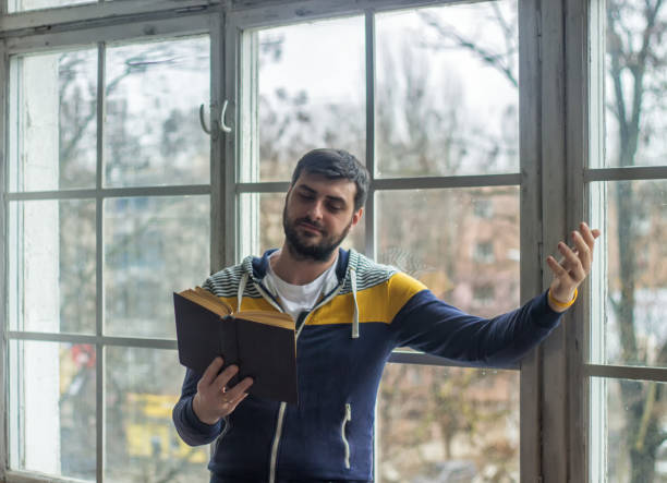istock Bearded poet man reads a book with an expression 657230298