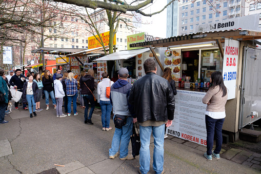 Portland, DeepMeta.Shared.Country: People lined up for lunch at food trucks in Portland Oregon.