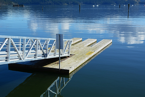 Kayak slips on wooden dock on bay with metal access ramp