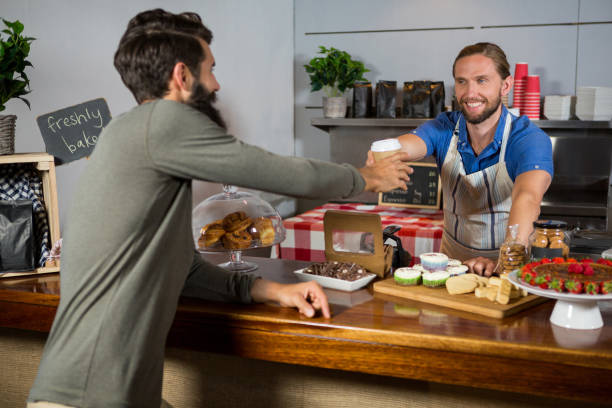 istock Smiling staff serving coffee cup at counter 657252766