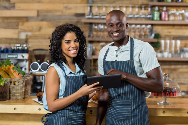 istock Smiling waiter and waitress using digital tablet at counter in cafe 657265048