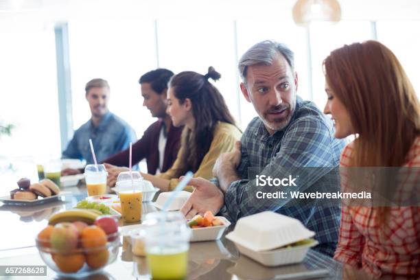 Creative Business Team Discussing While Having Meal Stock Photo - Download Image Now