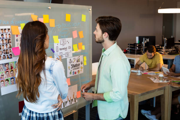 istock Creative business people looking at sticky notes on glass board 657271282
