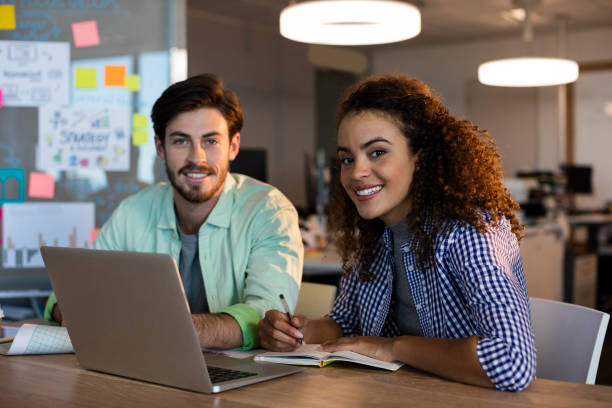 istock Smiling creative business people with laptop working at desk in office 657273618