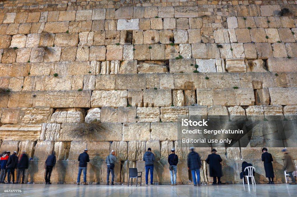 Daily Prayer at Western Wall, Old City, Jersalem, Israel Jerusalem, Israel - January 25, 2017: Praying at the Western 'Wailing' Wall of Ancient Temple in Jerusalem, Israel. Western wall of the Ancient Jewish Temple built in 100BC by Herod the Great on the Temple Mount. Judaism's most holy site. Jerusalem Stock Photo
