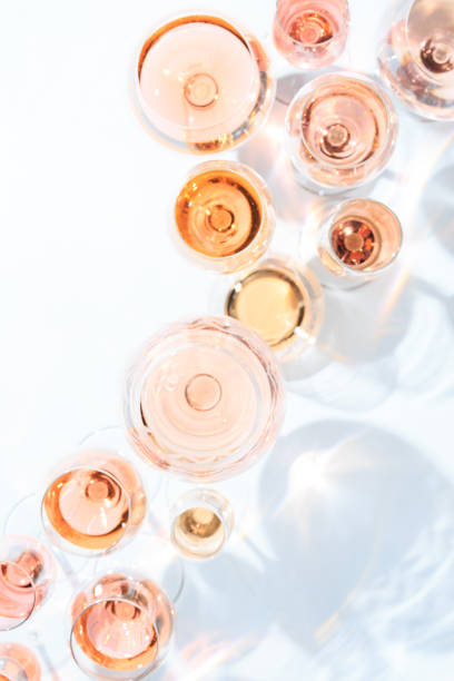 Many glasses of rose wine at wine tasting. Concept of rose wine and variety Many glasses of rose wine at wine tasting. Concept of rose wine and variety. White background. Top view, flat lay design. Direct sunlight. Vertical winetasting rose wine wineglass elegance stock pictures, royalty-free photos & images