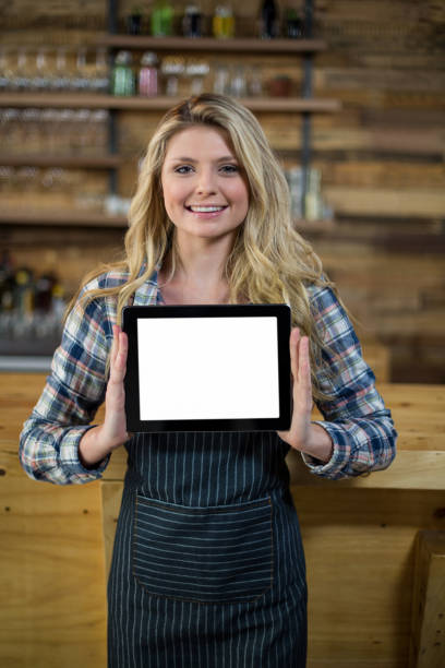 istock Portrait of smiling waitress showing digital tablet 657287682