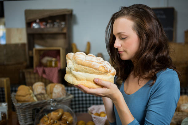 istock Woman smelling bread at bakery counter 657290186