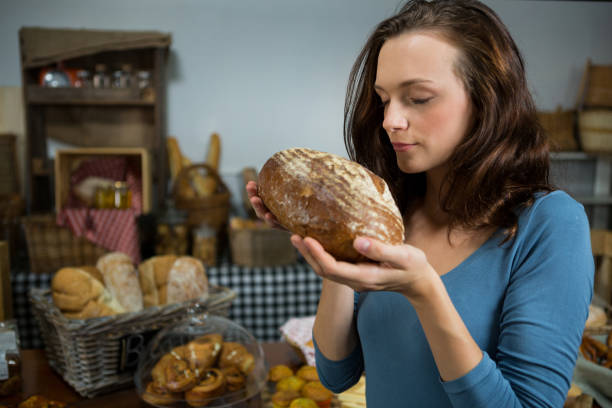 istock Woman smelling bread at bakery counter 657290196