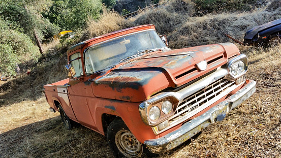 Scrapped, old but usable car parts are lined up in the junkyard.