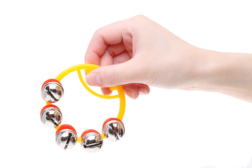 Hand holding colorful hand bells on a white background